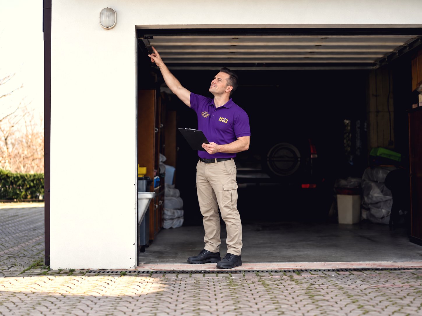 Aston Locks locksmith inspecting a garage door during a security survey
